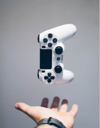 an image of a gaming controller levitating about someone's open palm